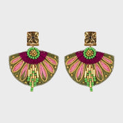 Pair of colorful earrings with gold, pink, and green details on a light gray background