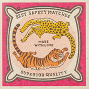 Caja de fósforos Chasing Big Cats de Aura Collective: diseño en rosa con un leopardo y un tigre enfrentados en círculo, con el texto Best Safety Matches, Made With Love y Superior Quality.