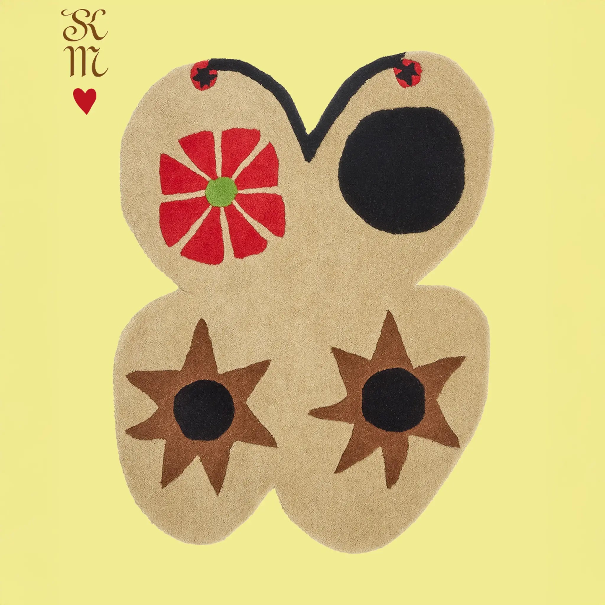 butterfly-shaped decorative rug with red, black, and brown patterns on a yellow background