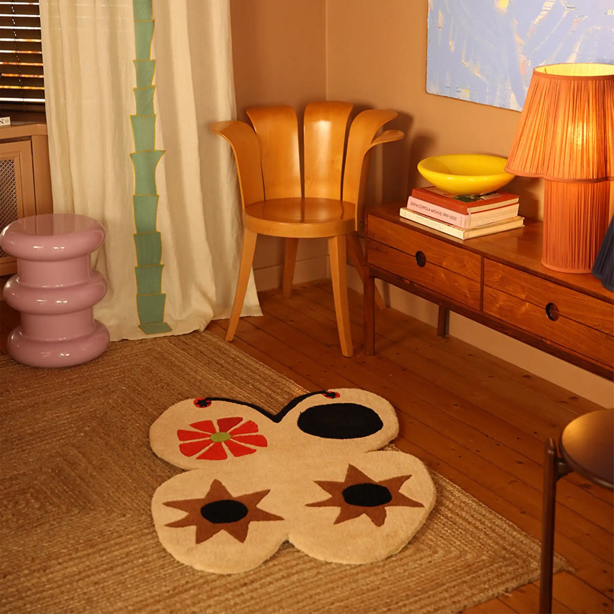 Room interior with a colorful rug, wooden chair, and sideboard.