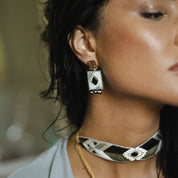 Close-up of a woman wearing earrings and a choker with a blurred background