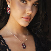 Close-up of a woman wearing a necklace and earrings with a blurred background