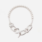Silver chain necklace with pearl-like beads on a white background