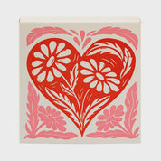 Vista frontal de la caja de fósforos Heart Box de Aura Collective, con el mismo diseño de corazón rojo y flores en rosa.