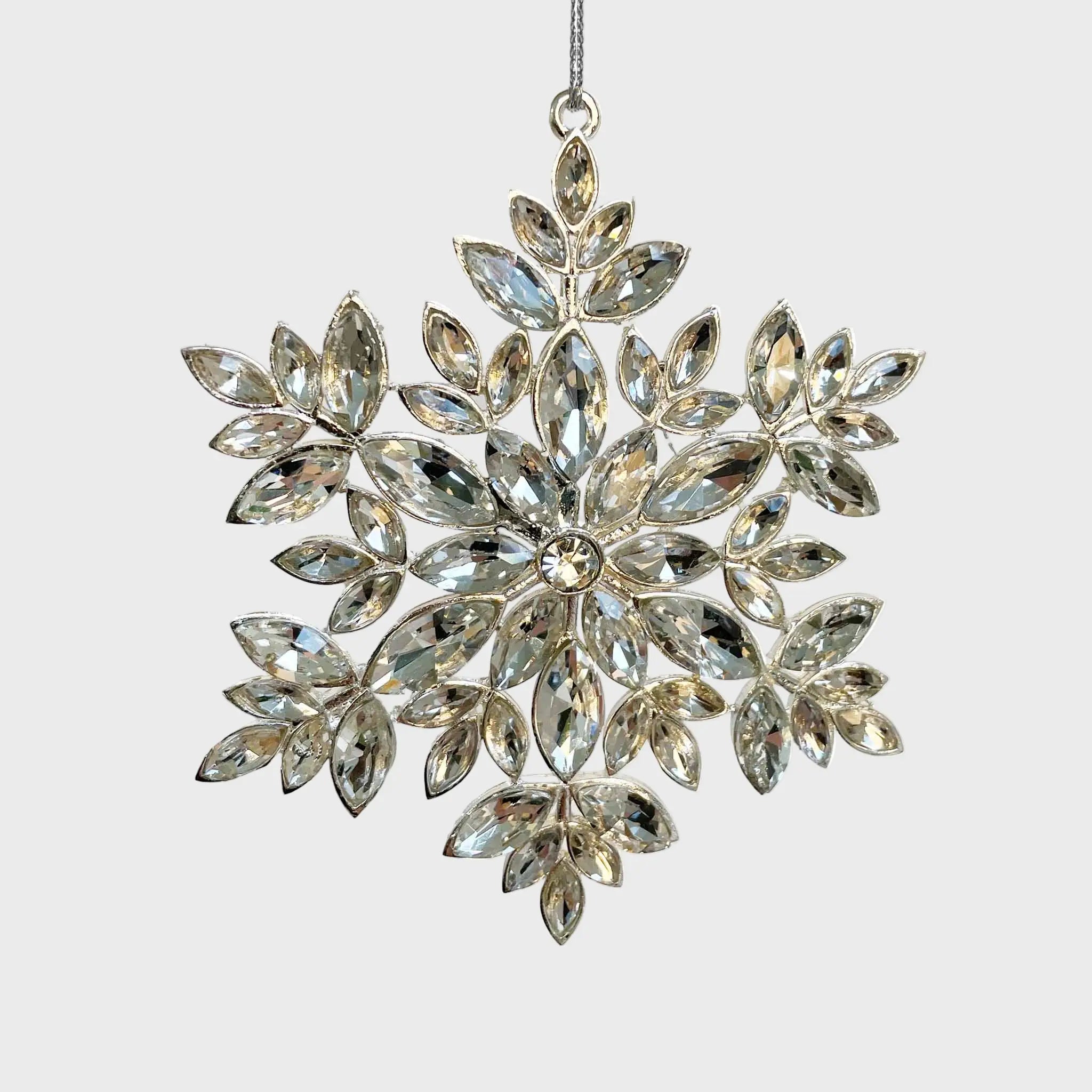 Decorative snowflake ornament with crystal-like stones on a white background