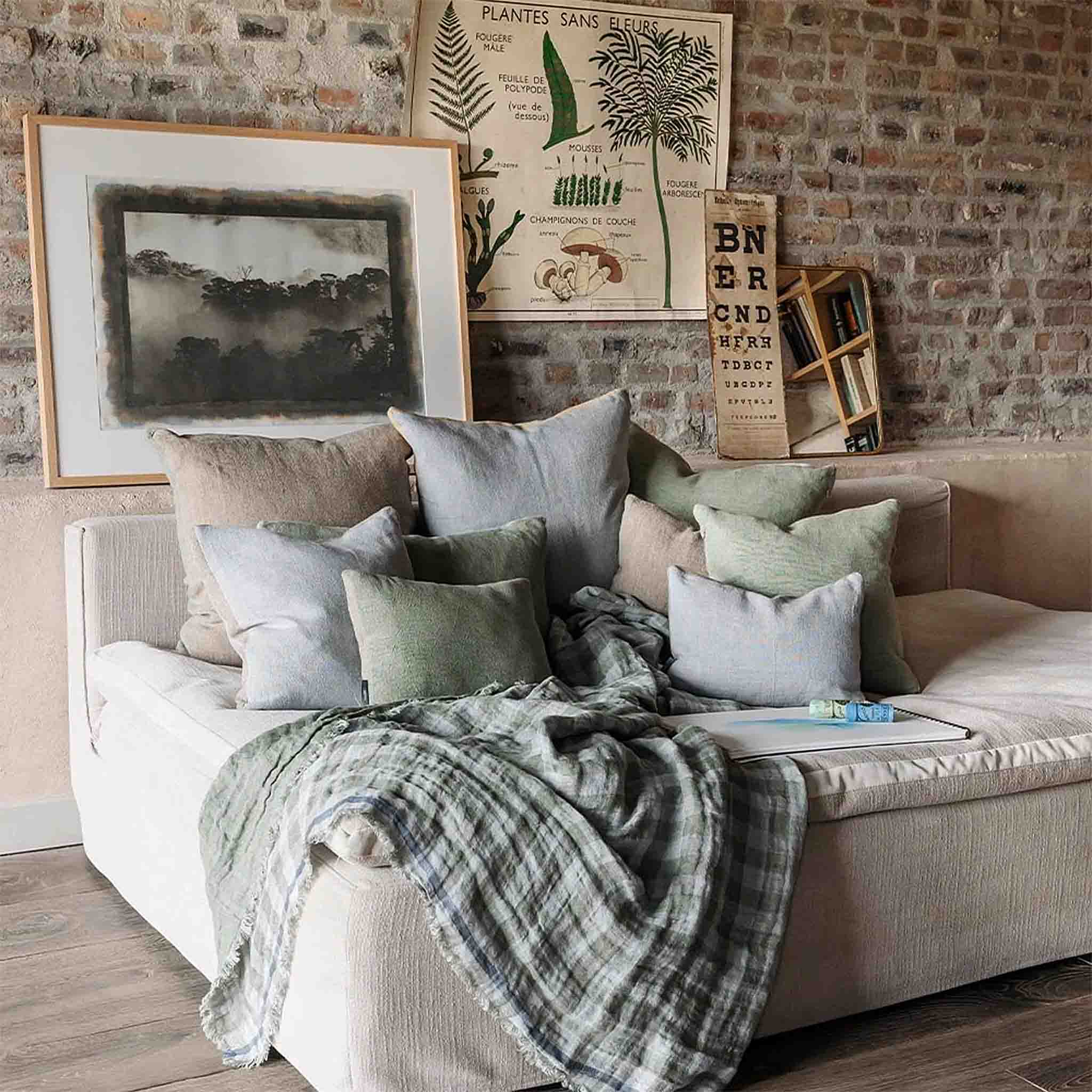 Square Jim Cushions styled on a white sofa with blue and sage linen pillows
